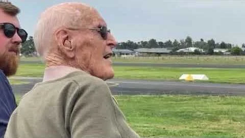 Jock Cassels watching a Spitfire at an airfield